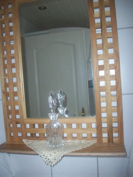 Eine selbstgebastelte Spiegelablage aus einem Einlegeboden des Schranks.