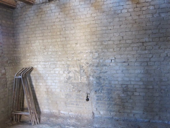 Doppelte Kalksandsteinmauer innenbelüftet; dennoch ist der Putz abgefroren. Die Öffnung in der Wand stellte den Durchbruch für das Abwasser des Küchen